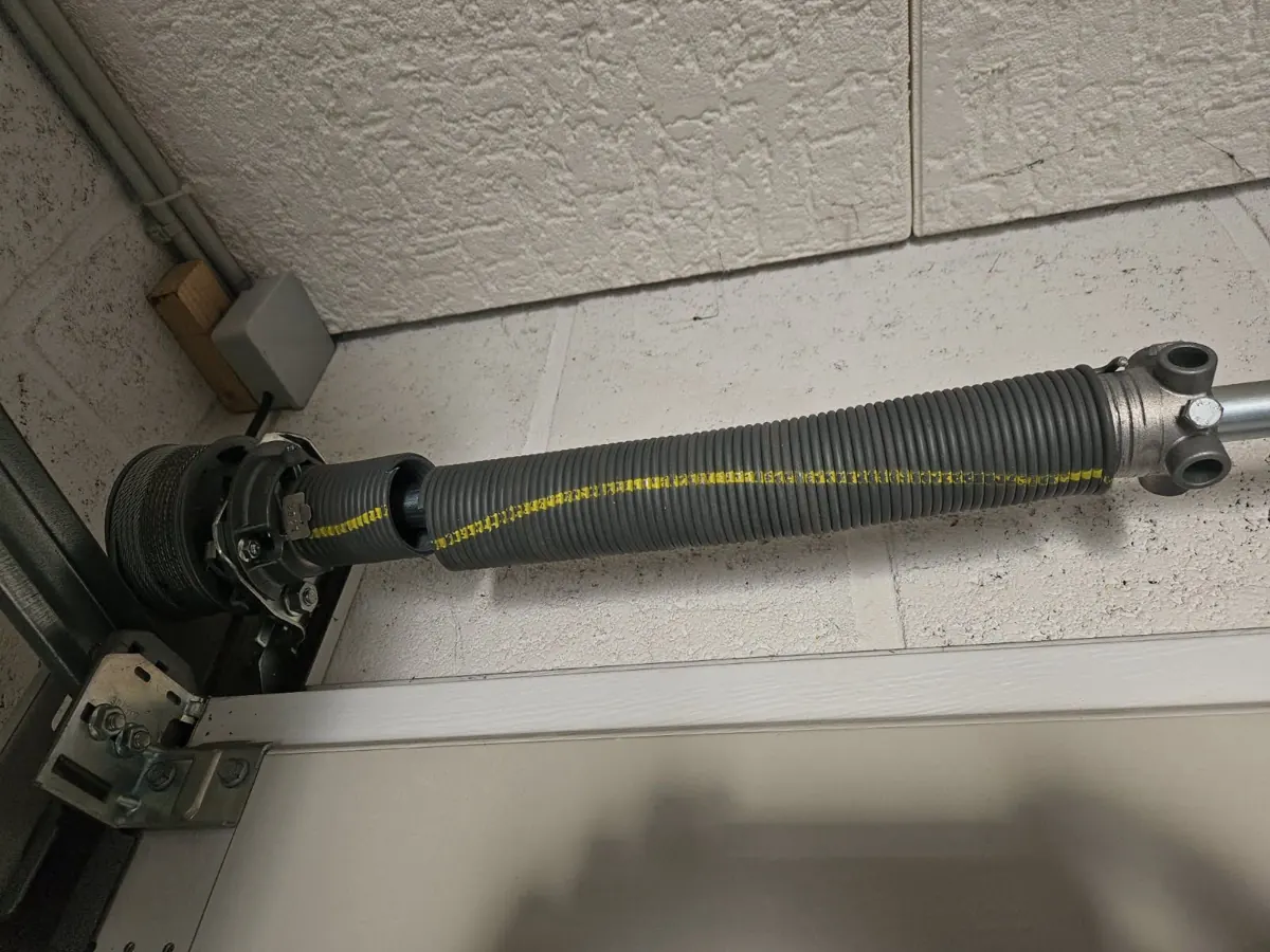 Arbre et ressort de torsion au-dessus d'une porte de garage sectionnelle