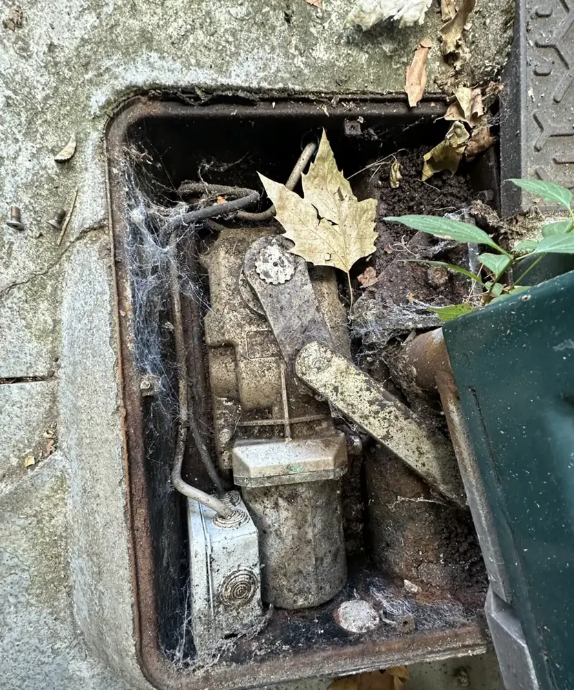 Caisson de moteur enterré encrassé par la terre et les feuilles, avant nettoyage et remise en état