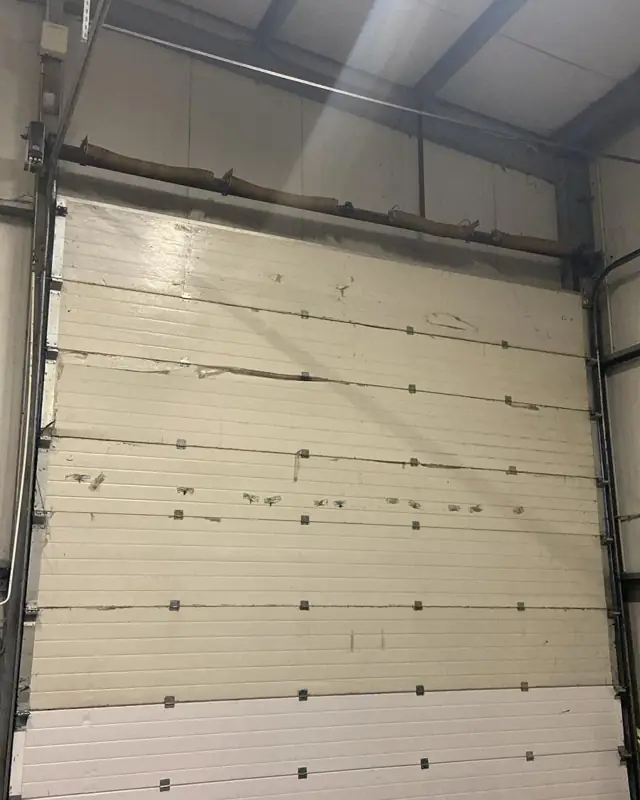 Porte de garage sectionnelle blanche dans un local d'activité