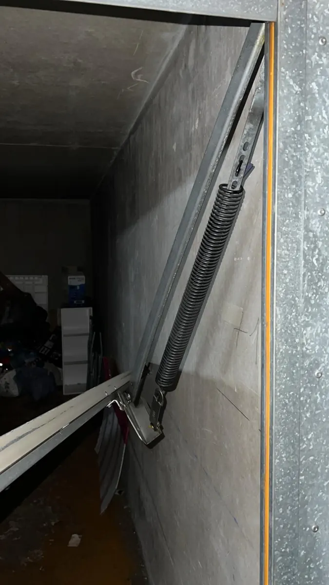 Ressort latéral et bras de guidage d'une porte de garage basculante