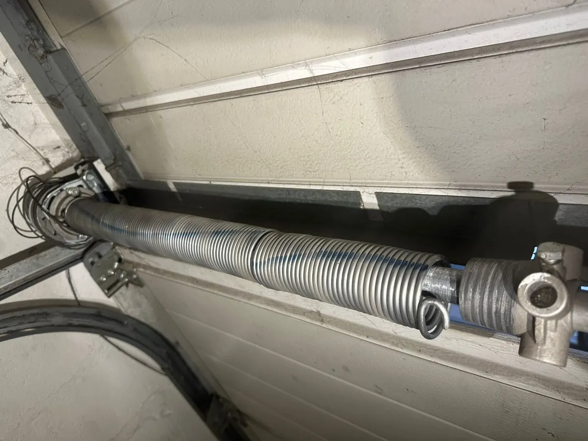 Ressort de torsion neuf monté sur l'arbre d'une porte de garage sectionnelle
